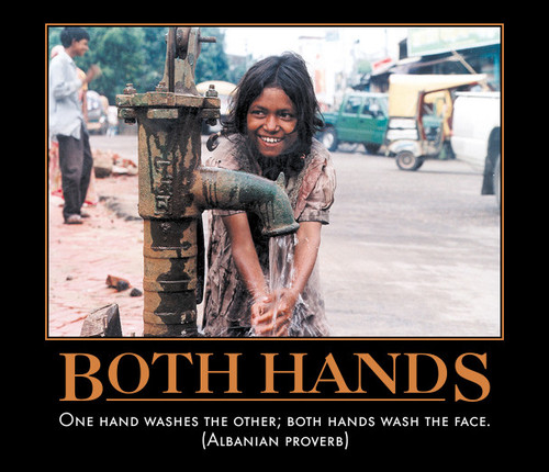 woman washes hands at water pump