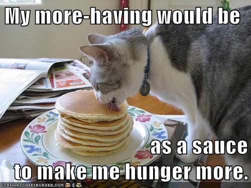 cat licks tall stack of pancakes